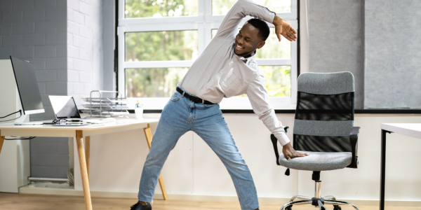 working-male-stretching-at-desk